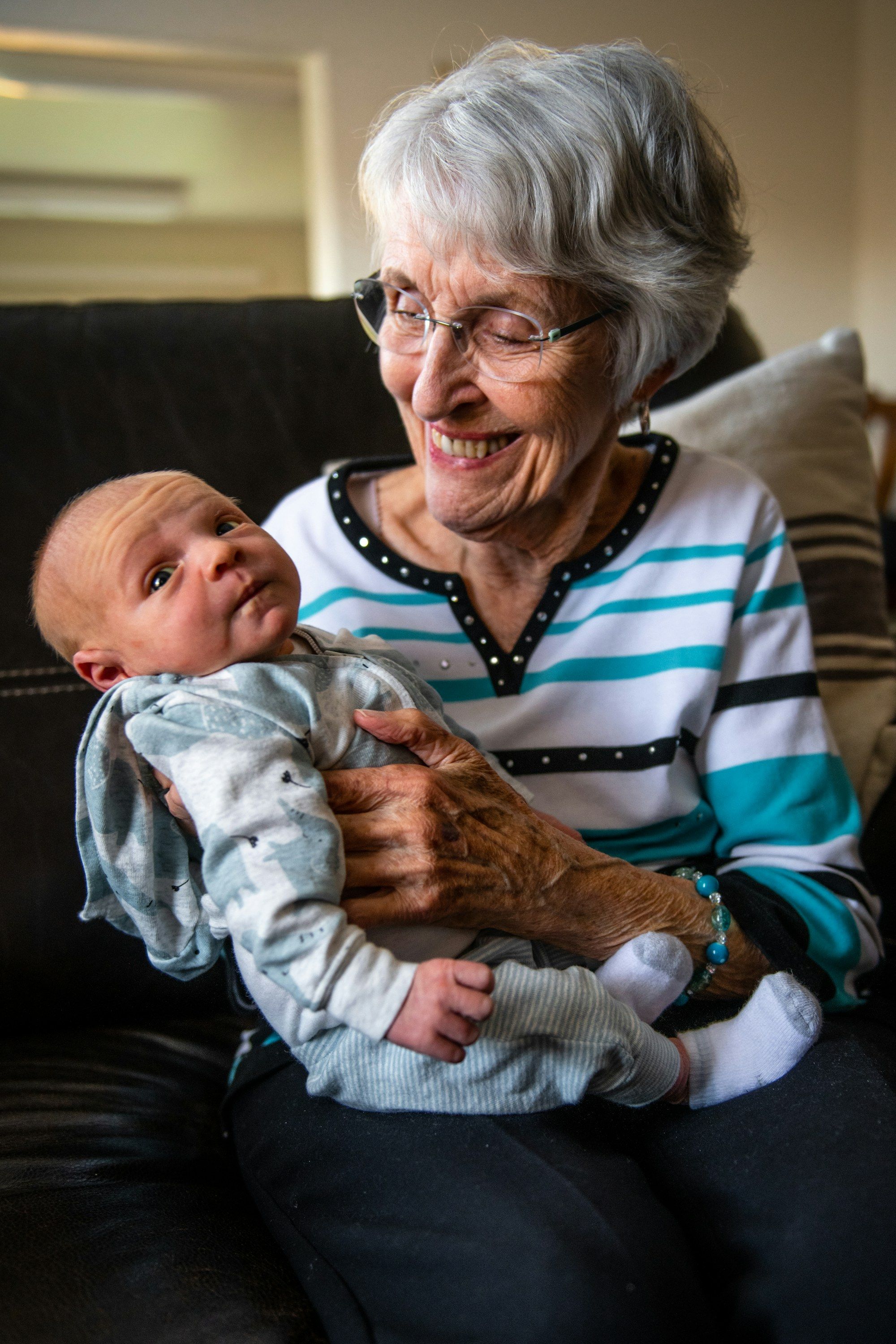 A smiling grandmother holding a baby
